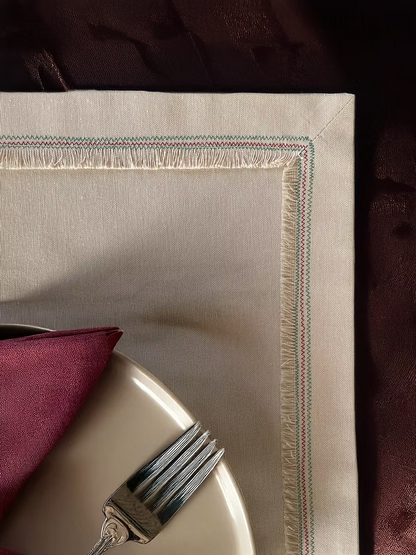 Nappina Placemat Set of 4-Beige placemat with a red napkin and silver fork on a dark surface