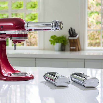 Red stand mixer with pasta attachments on a kitchen counter