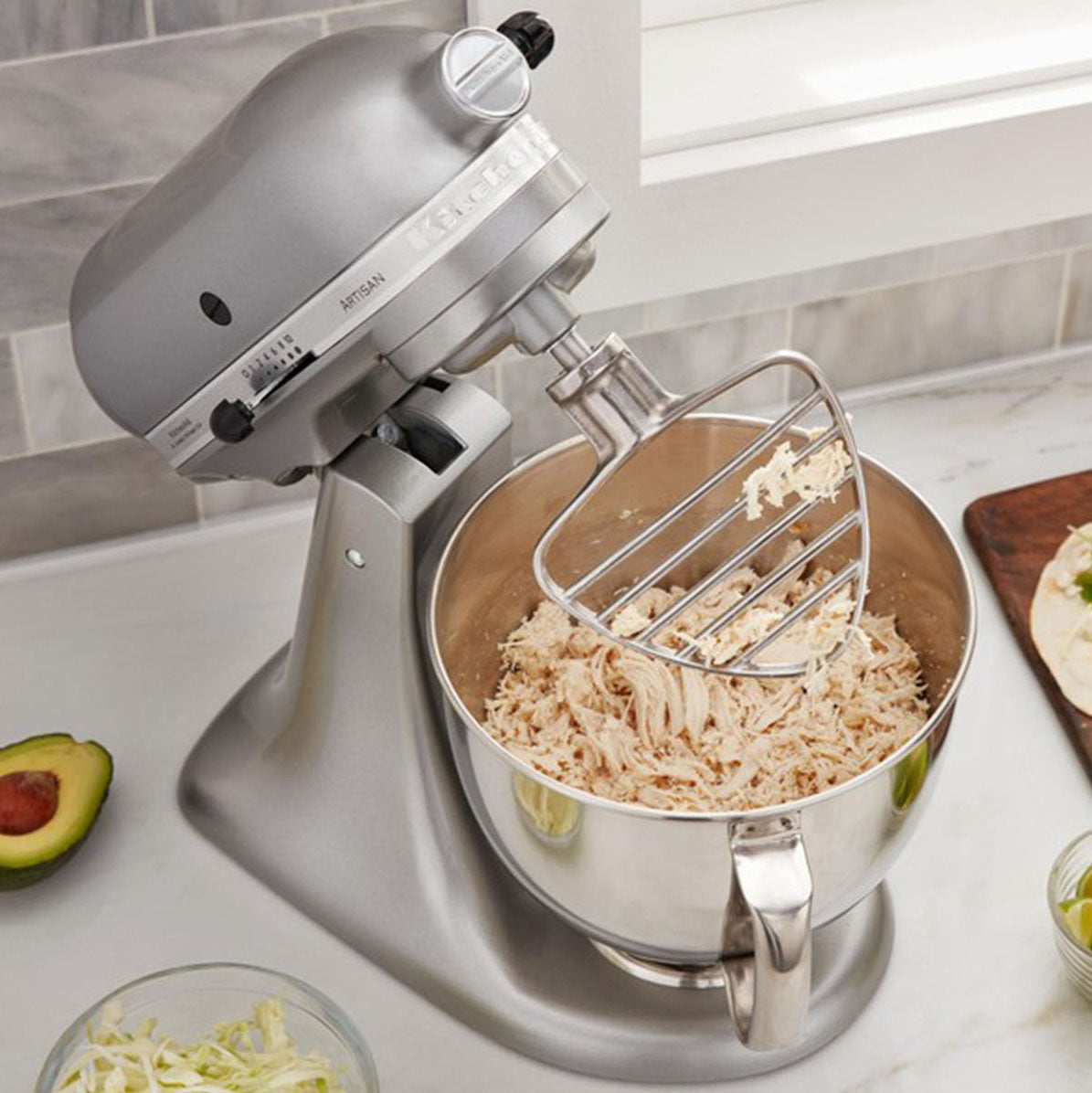 KitchenAid stand mixer with a bowl of food on a kitchen counter