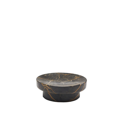 Round black marble coaster with gold veins on a white background