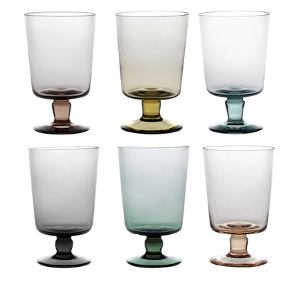 Set of six colored glass goblets on a white background
