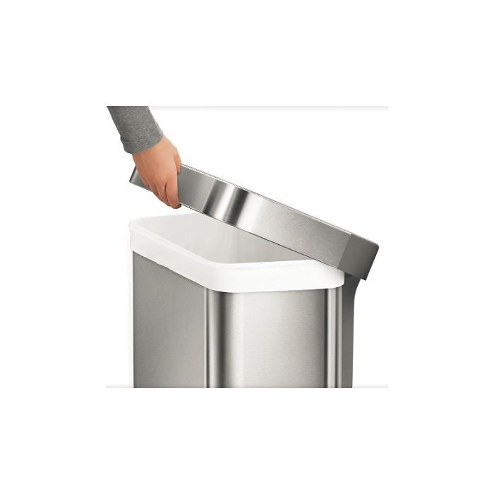 Simplehuman Rectangular Pedal Bin with Liner Pocket Stainless steel trash can with a hand lifting the lid 