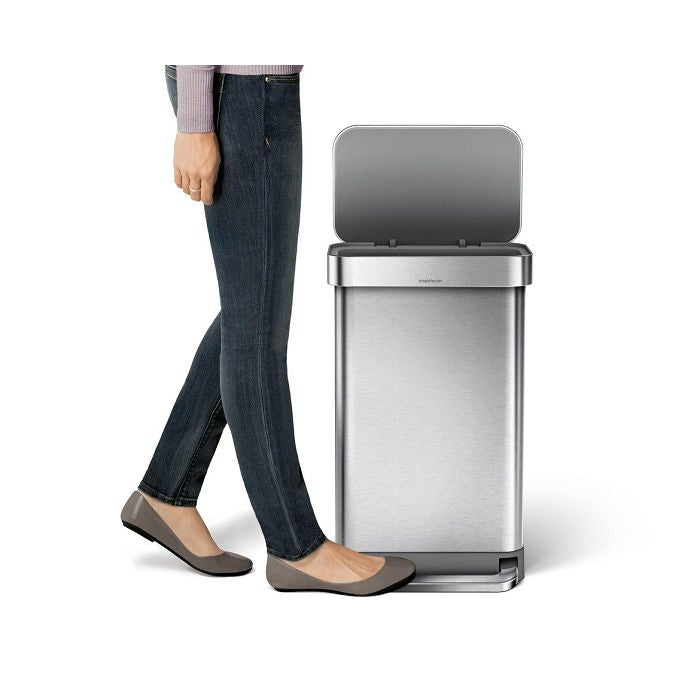 Simplehuman Rectangular Pedal Bin with Liner Pocket Person standing next to a large stainless steel trash can 