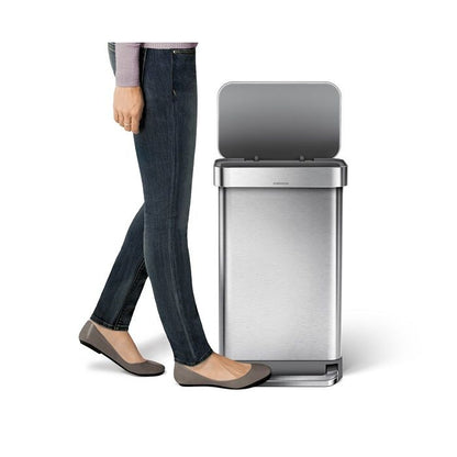 Simplehuman Rectangular Pedal Bin with Liner Pocket Person standing next to a large stainless steel trash can 