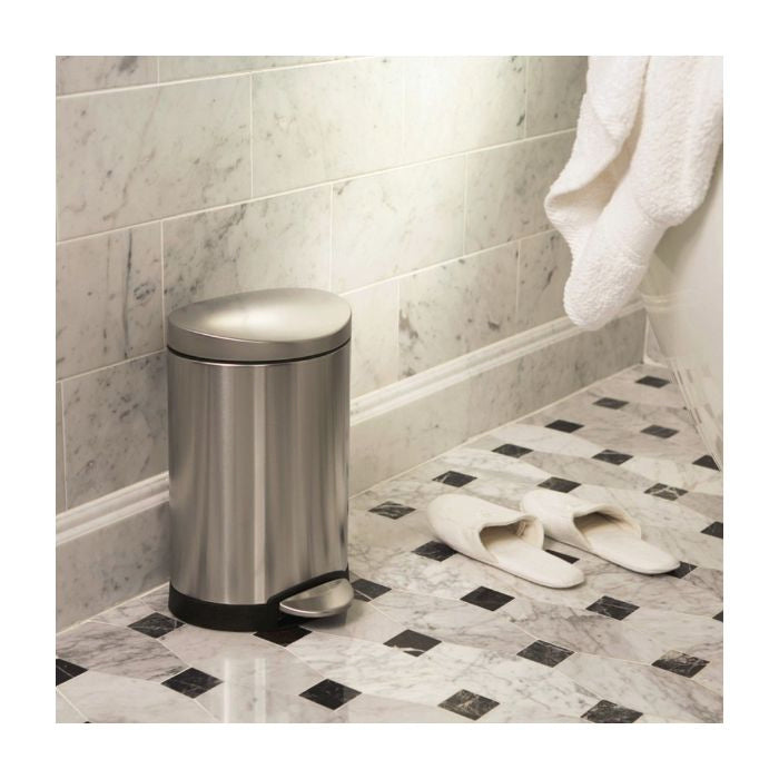 Simplehuman Semi Round Bin, 6 L-Silver trash can in a bathroom with tiled floor and towel.