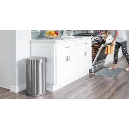 Simplehuman Semi Round Sensor Bin With Liner Pocket-Stainless steel trash can in a kitchen setting with a person opening an oven.