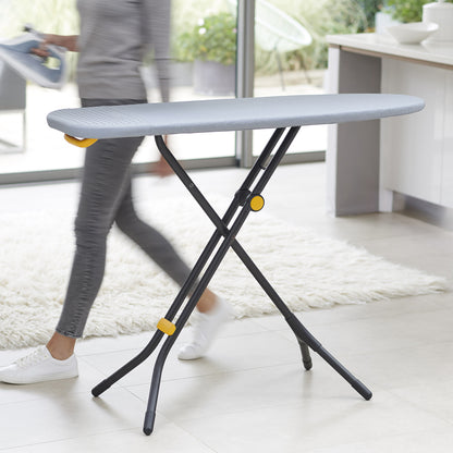 UAE laundry room-Person using an iron on a portable ironing board in a home setting