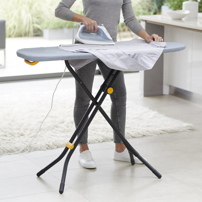 UAE laundry room-Person ironing a shirt on a portable ironing board in a kitchen.