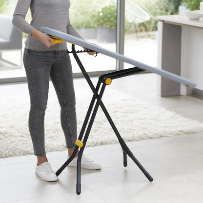 UAE laundry room-Person using a portable ironing board stand indoors.
