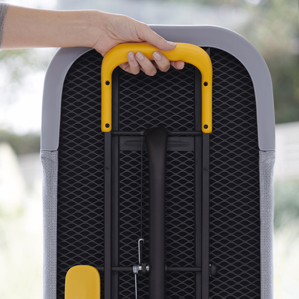 UAE laundry room-Hand holding a yellow handle of a gray suitcase with a blurred outdoor background
