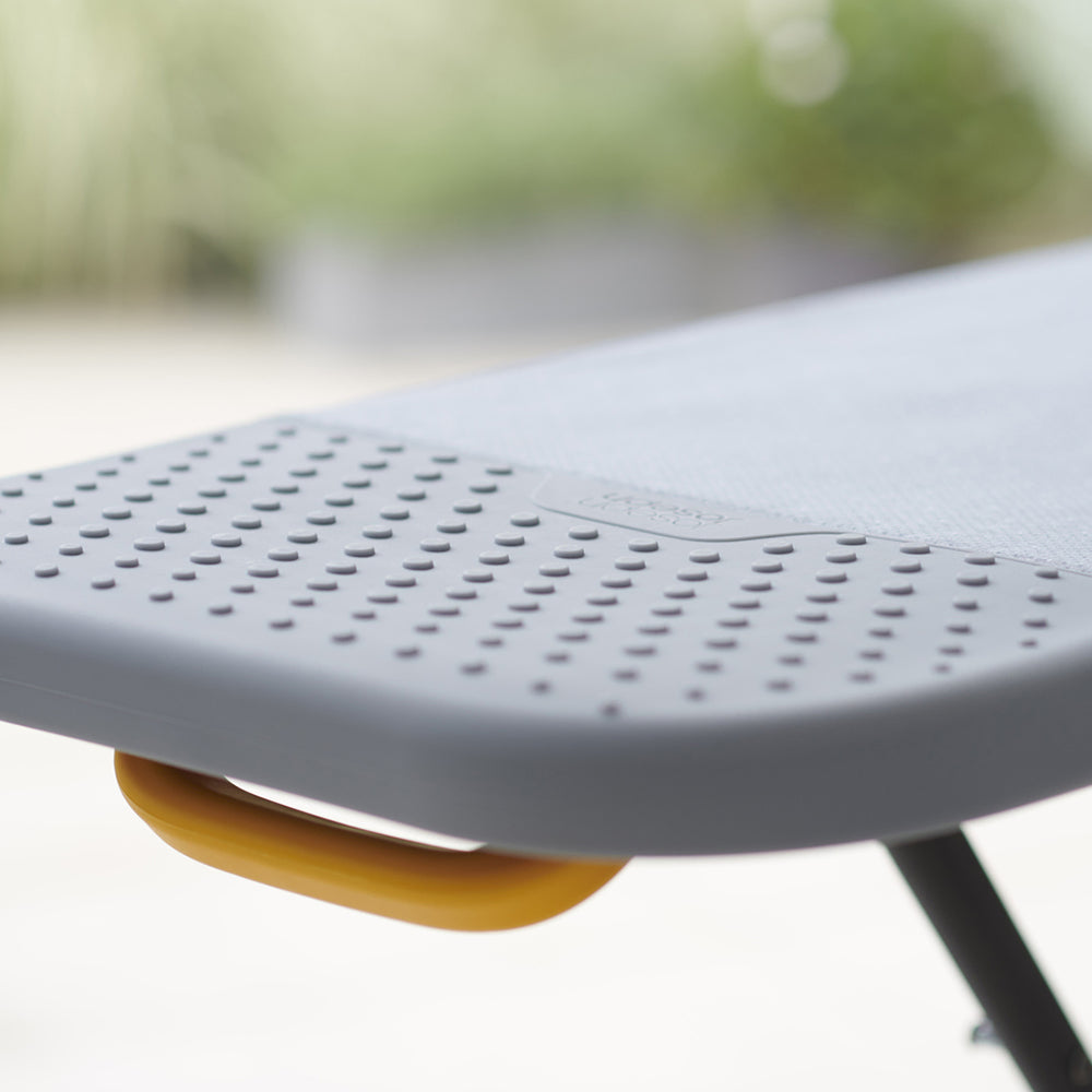 UAE laundry room-Gray chair with a yellow footrest on a blurred outdoor background