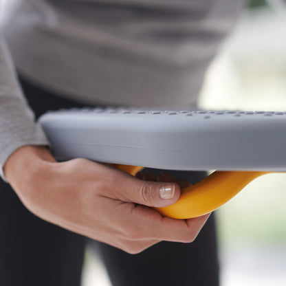 UAE laundry room-Person holding a gray and yellow object with a blurred background