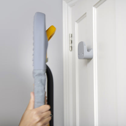 UAE laundry room-Hand holding a gray door handle against a white door