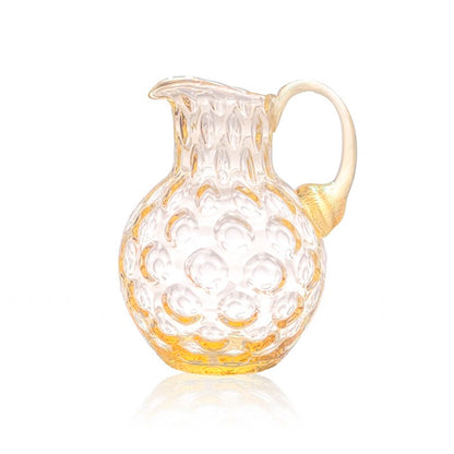 Clear glass pitcher with gold accents on a white background