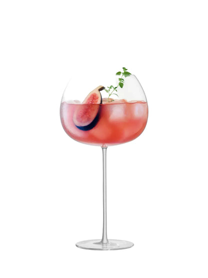 cognac glass-Cocktail in a glass with a slice of fruit and garnish on a white background