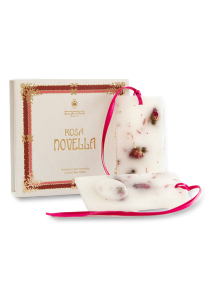 A package of Santa Maria Novella Rosa Novella scented wax tablets, with the product name displayed on the box, adorned with a pink ribbon and rose bud embellishments.