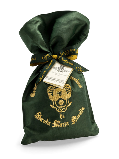 A green embroidered silk bag with gold brand embroidery and a drawstring closure, containing pot pourri.
