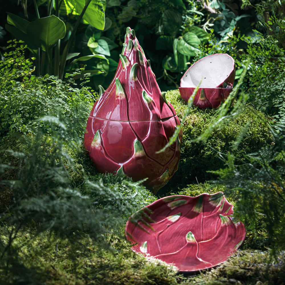 Red ceramic dragon fruit with green accents on a green background