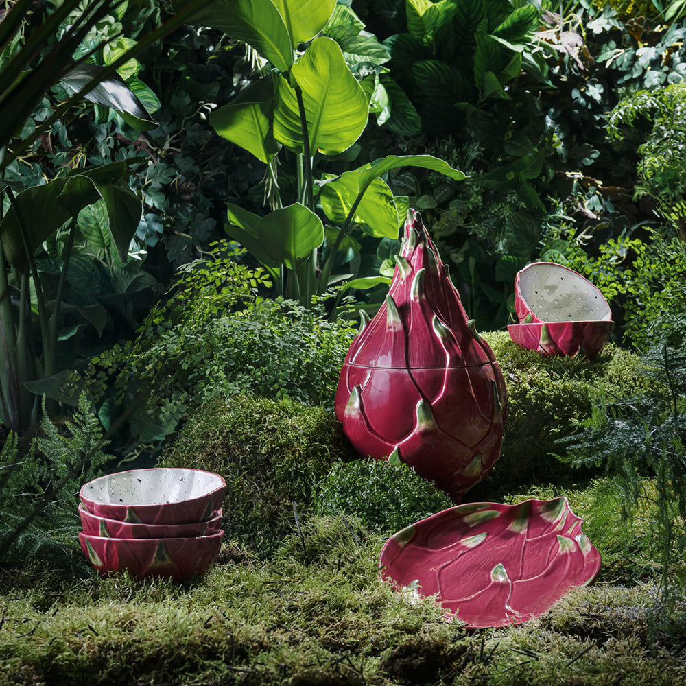 Pink dragon fruit-shaped planters in a garden setting