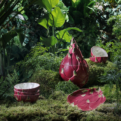 Pink dragon fruit-shaped planters in a garden setting