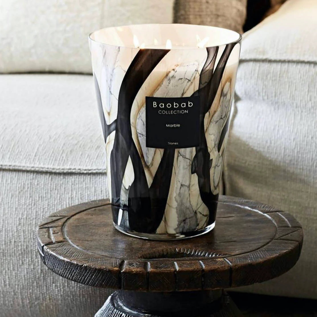scented candles-Marble-patterned candle with 'Baobab Collection' label on a wooden stand.