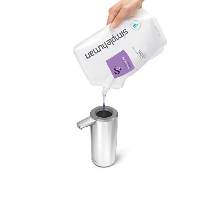 simplehuman Rechargeable Sensor Soap Pump-Hand filling a metallic soap dispenser with Simply Human hand soap.