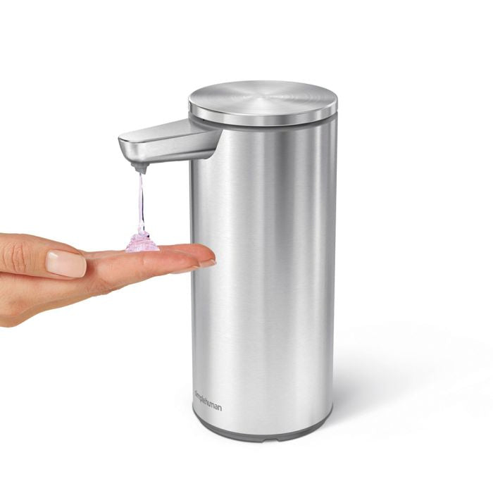 simplehuman Rechargeable Sensor Soap Pump-Stainless steel soap dispenser with hand pressing the pump, on a white background